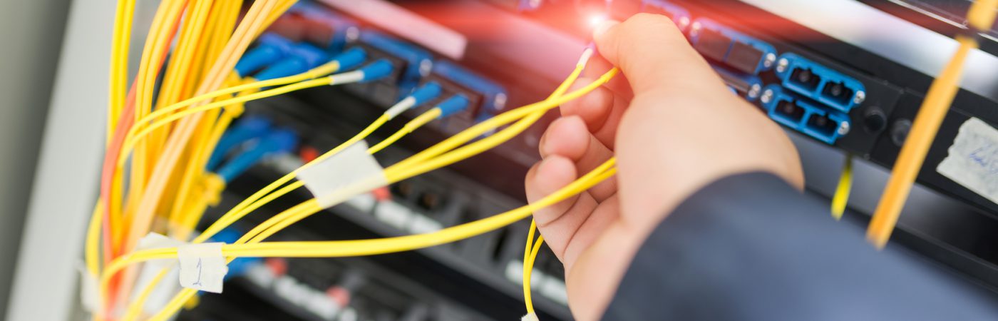People fix node fiber optic in network room .